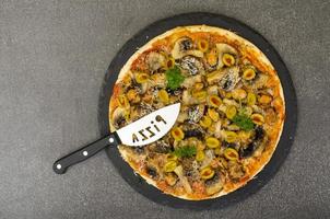 pizza med musslor, champinjoner, gröna oliver. studiofoto