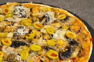pizza med musslor, champinjoner, gröna oliver. studiofoto