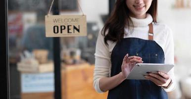 vacker ung försäljare som använder sin digitala surfplatta i ekologisk butik. foto