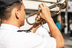 militär man av tillbaka spelar en trumpet i de parad. foto