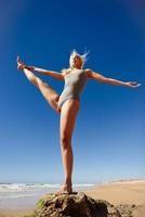 kaukasisk blond kvinna utövar yoga på stranden foto