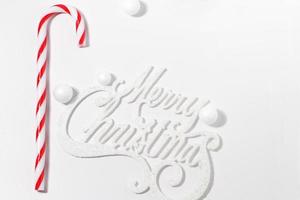 merry christmas card med röd godis käpp på vit bakgrund med hårt ljus foto