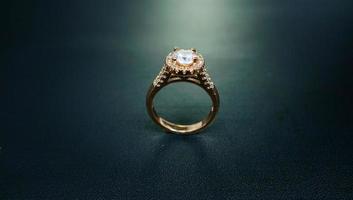 foto av kvinnors ring med ädelstensdiamanter på en svart bakgrund