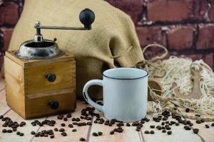 rostade kaffebönor och en vitage kaffekvarn foto