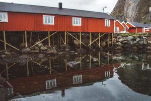 norge rorbuhus och berg klippor över fjordlandskap skandinavisk resevy lofoten öar. naturligt skandinaviskt landskap.