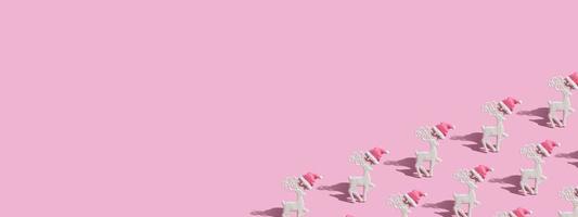 mönster med en glamorös ren i en tomtehatt på en rosa bakgrund med kopia utrymme