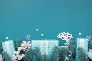jul platt låg bakgrund med presenter, bär och tall på turkos bakgrund med kopia utrymme foto