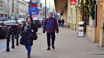 Warszawa, polen. 29 december 2023. människor av annorlunda åldrar och nationaliteter promenad tvärs över i de stad Centrum, vinter- tid. människor på de gata. foto