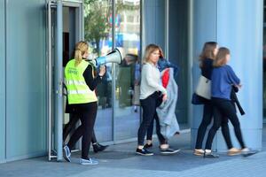 Warszawa, polen. 15 oktober 2018. evakuering av ett kontor byggnad. människor utgång de byggnad på utgång dörr. foto