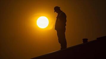 silhuett av brandman stående på tak på solnedgång, uppfyllande fallen hjältar med respekt och sorg. begrepp av fara, mod, och förlust. foto