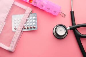 födelse kontrollera piller och stetoskop på rosa foto
