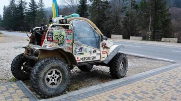 ukraina, bukovel - 20 november 2019. barnvagnar med klistermärken och en blå-gul flagga på parkeringsplatsen vid semesterorten bukovel i västra ukraina. liten lätt suv. foto