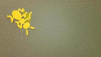 gulmålad myra på en grå vägg. myra klättrar på en vägg. färgglada myror bakgrunder. lokala konstnärer dekorerar gatornas väggar. foto