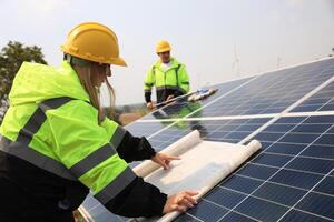 framtida elektrisk produktion. manlig och kvinna kollegor läsa teckning arbete utomhus av sol- paneler, grön energi, och förnyelse energi begrepp foto