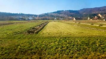 landskapsvy av en bergsby i Karpaterna på hösten från tågfönstret. en vy från ett gammalt tåg i en bergsby foto