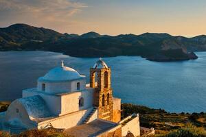 grekisk ortodox kyrka i plaka by på milos ö på solnedgång i grekland foto