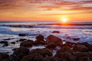 atlanten hav solnedgång med vågor och rocks. costa da caparica, portugal foto