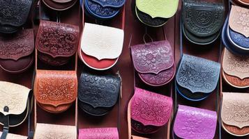 souvenirmarknad i yaremche. axelväskor i färgat läder för kvinnor präglade med ett karpatmönster. väskor och accessoarer till försäljning. Ukraina, Yaremche - 20 november 2019 foto