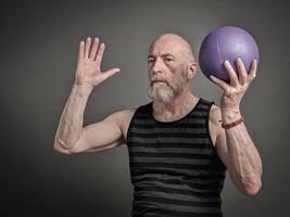 atletisk senior man med en små medicin boll foto