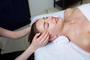 skön ung kvinna få ansiktsbehandling massage i spa salong. skönhet behandling begrepp. foto