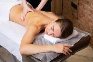 ung kvinna få en tillbaka massage i en spa salong. skönhet behandling begrepp. foto
