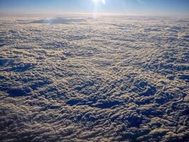 soluppgång moln matta se från flygplan fönster medan flygande foto