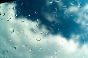 vatten droppar på glas mot blå himmel, regnig säsong begrepp. fönster se bakgrund skärmsläckare foto