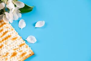 Semester påsk flatlay. traditionell matzah bröd och vår blommor på blå bakgrund. foto