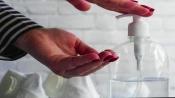 närbild av kvinnliga händer som tvättar händerna med alkoholgel. flickan trycker på dispensern och häller alkoholbaserad vätska. ett desinfektionsmedel för att eliminera bakterier och virus. covid19. foto