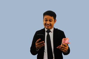 vuxen asiatisk man avfall hans pengar för uppkopplad handla använder sig av mobil telefon foto