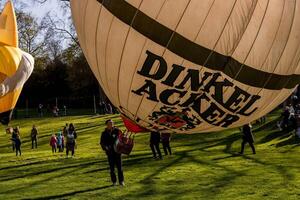 ludwigsburg, Tyskland - Mars 23, 2024.a man blåses upp en ballong på en ballong festival foto