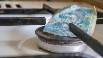 ukrainska hryvnian på en gas varmvattenberedare utan eld. gasspis med pengar. konceptuell bild av en stigande taxa för våld. naturgasbesparande koncept hemma, höga gaspriser. foto