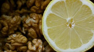 vitamin diet och näring bakgrund. valnöt kärnor och skivad saftig citron- frukt närbild stock Foto