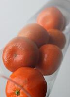 hela mogen mandariner spill ut av en tunn glas närbild stock Foto
