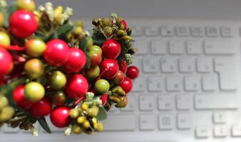 dekorativ artificiell bär och löv över defocused anteckningsbok tangentbord foto