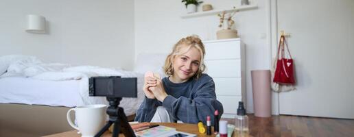 porträtt av skön blond kvinna, flicka visar rodnar, skönhet Produkter, inspelning på digital kamera, skapande innehåll för social media konto, vlogger rekommenderar objekt i vlog foto