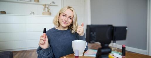 ung karismatisk skönhet bloggare, Tonårs flicka uppgifter av henne applicering mascara, granskning smink Produkter för henne livsstil vlogg, vlogging för social media konto foto