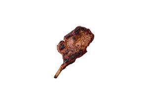utsökt saftig nötkött biff på de ben, tomahawk med salt, kryddor och örter foto