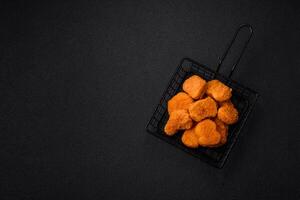 utsökt färsk Krispig kyckling nuggets på en mörk betong bakgrund foto