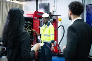 tekniker är införande industriell hand robotar till affärsperson av fabrik industri vem kommer använda sig av dem i storskalig komplex tillverkning operationer. foto