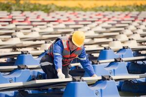 solceller ingenjörer arbete på flytande solceller. inspektera och reparera de sol- panel Utrustning flytande på de vatten. foto