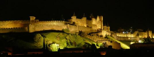 natt lampor på de vallar och slott torn av medeltida carcassonne foto