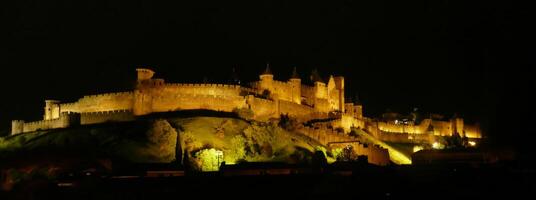 natt lampor på de vallar och slott torn av medeltida carcassonne foto