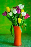 blomstrande tulpaner i en vas. färgrik blommor foto