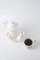 en kopp av ljuv te med en keramisk tekanna med en fågel på en vit bakgrund foto