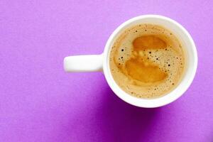 en kopp av kaffe på en lila bakgrund foto