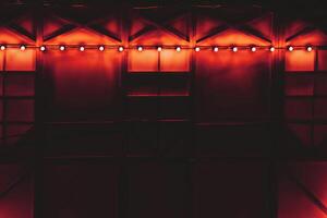 mörk draperad lysande dekorerad vägg med röd orange bakgrundsbelysning foto