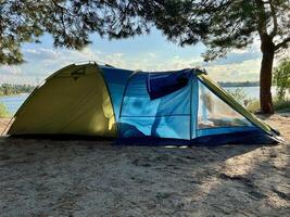 blå tält förbi de sjö. Semester och camping begrepp. dimma över de sjö. morgon- tid foto