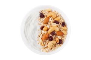 naturlig yoghurt med hemlagad granola och nötter i keramisk skål topp se isolerat vit bakgrund foto