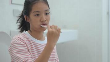 en flicka är pensling henne tänder i en badrum foto